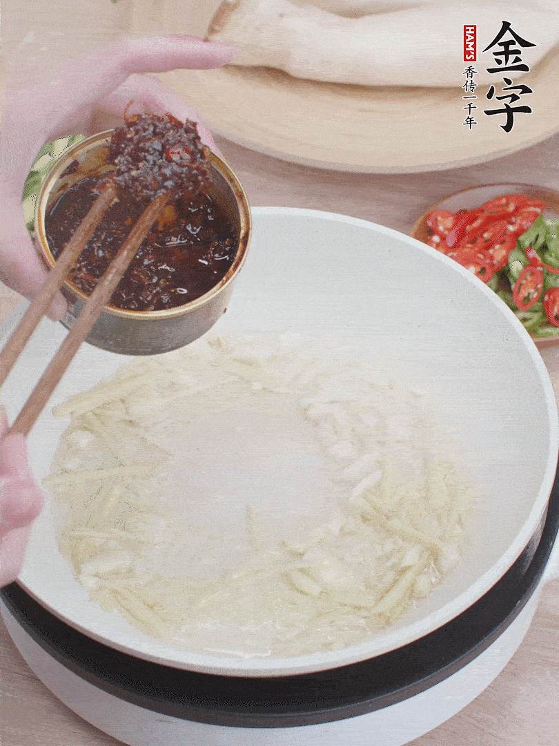 起鍋熱油，姜蒜、金字火腿干貝醬煸香。